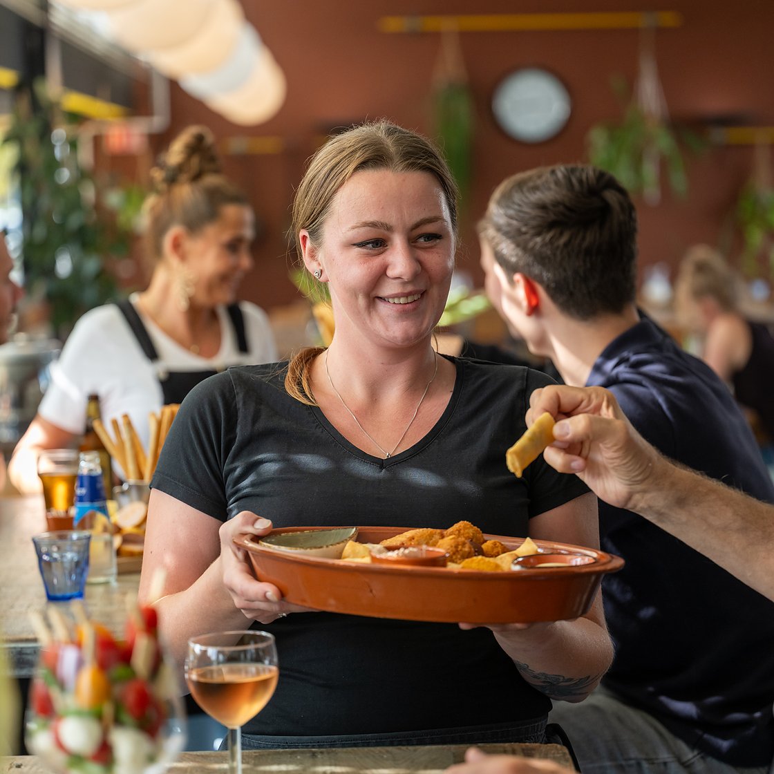 een schaal bittergarnituur wordt uitgeserveerd