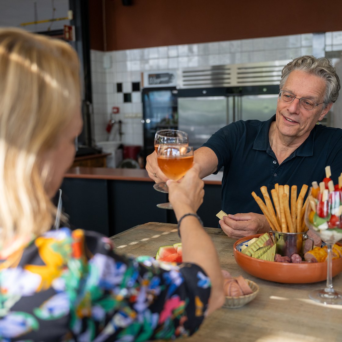 gasten die proosten met een biertje aan de bar