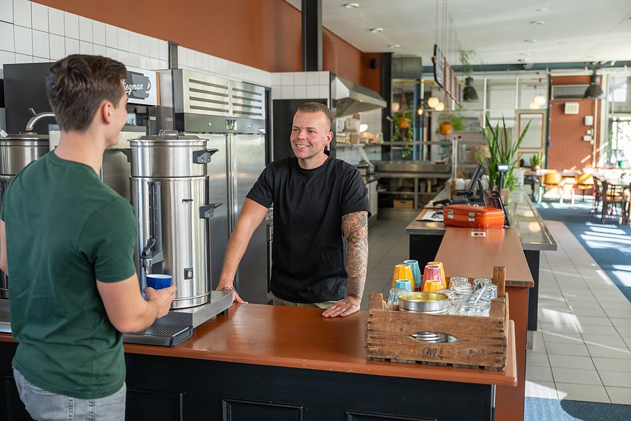 een gast haalt koffie aan de balie van Eetcafé Wiegman
