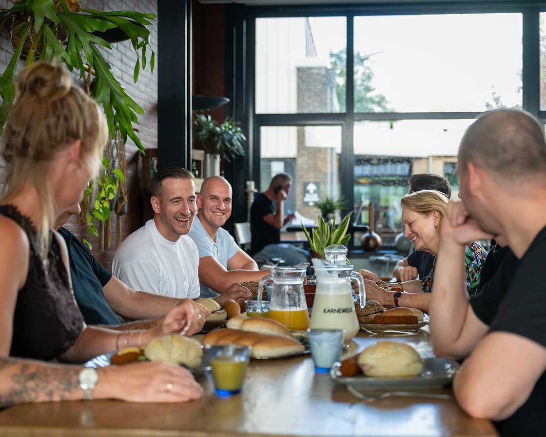 een gezelschap aan de lange tafel tijdens de lunch